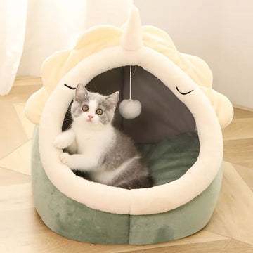 A cute dinosaur-shaped pet house with a dangling toy ball inside